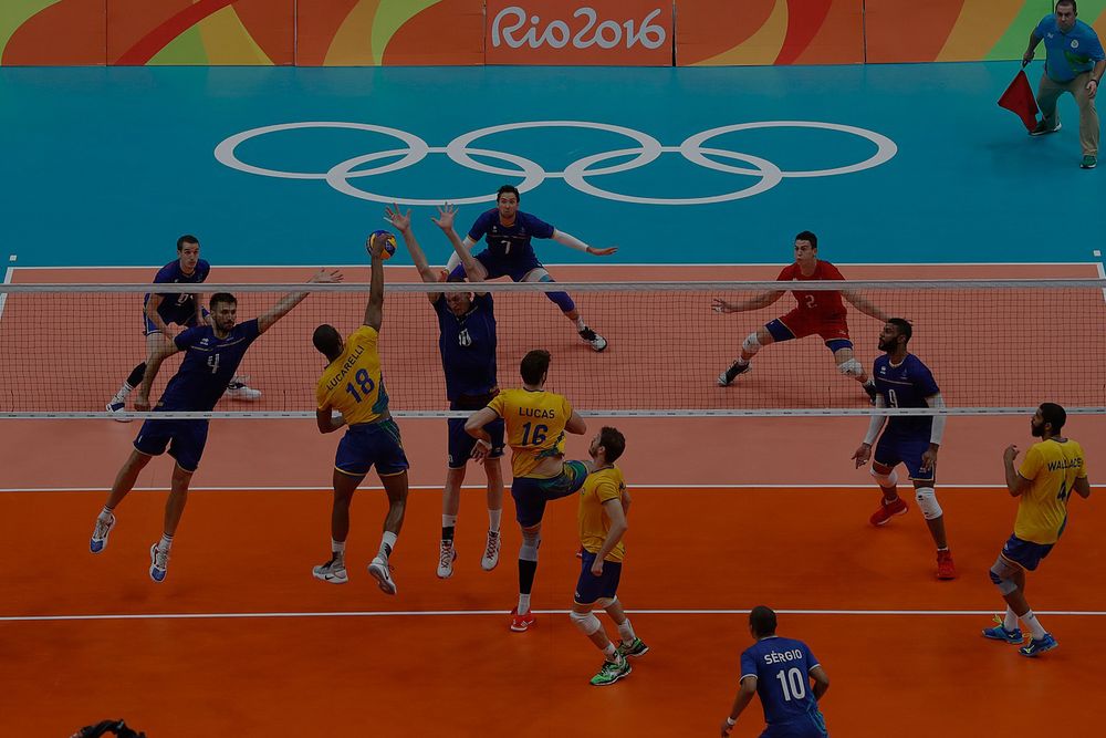 overlooking angle of two teams playing volleyball against each other in a olympic court 